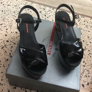 Prada black patent flat form sandals.